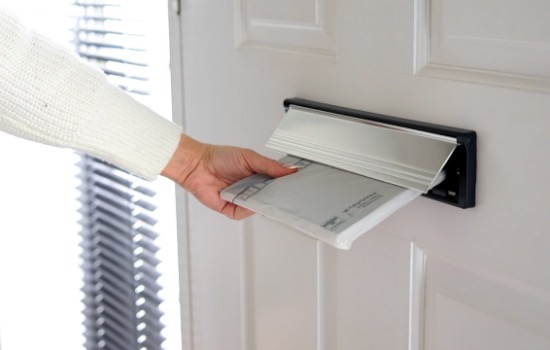A brochure being posted through a letterbox