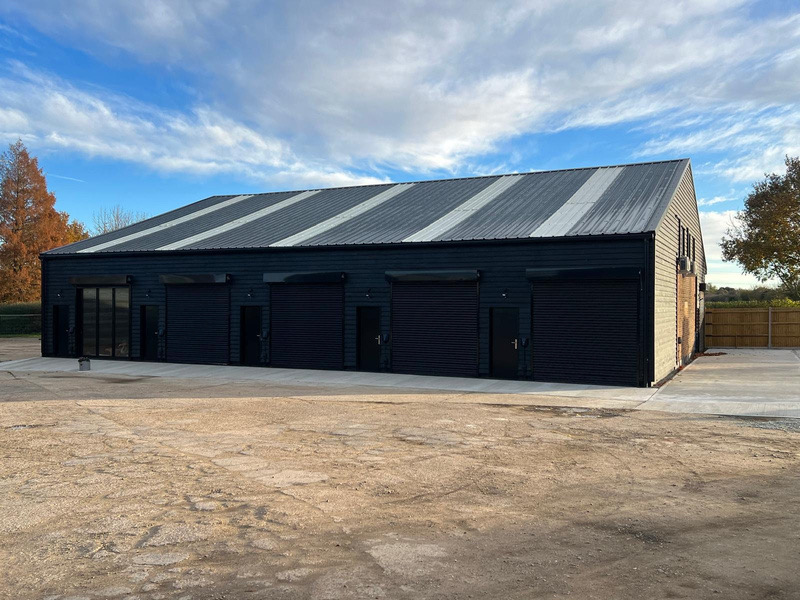 A large dark-clad commercial unit with roller doors